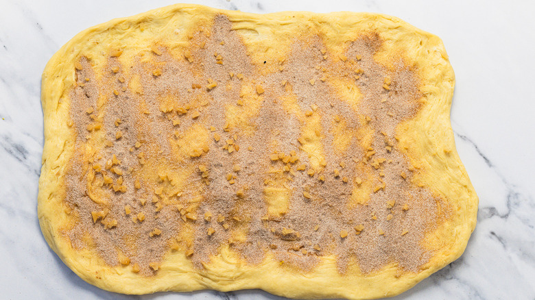 Streteched out cinnamon bun dough with toppings.