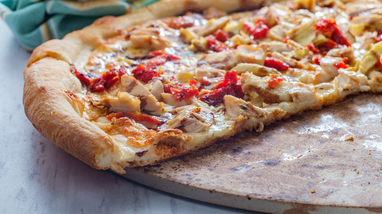 Sliced pizza on a pizza stone.