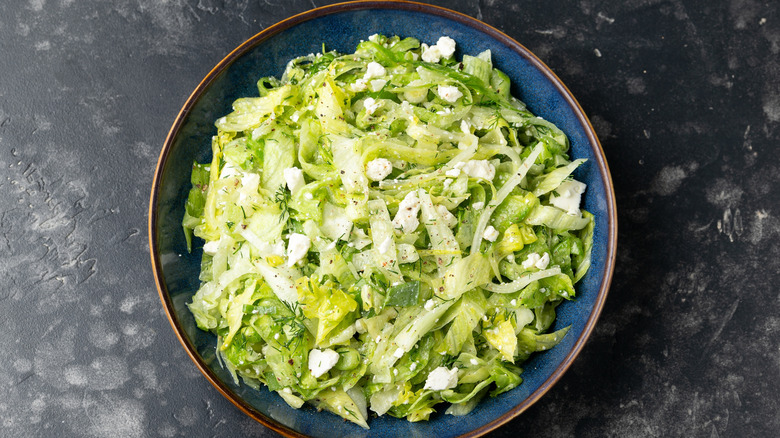 Dressed salad with shredded lettuce and cheese crumbles