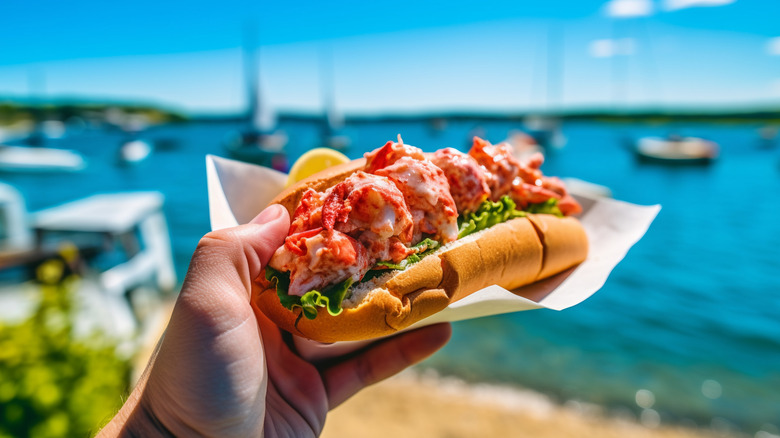 Foodie holding a lobster roll beside the waterfront