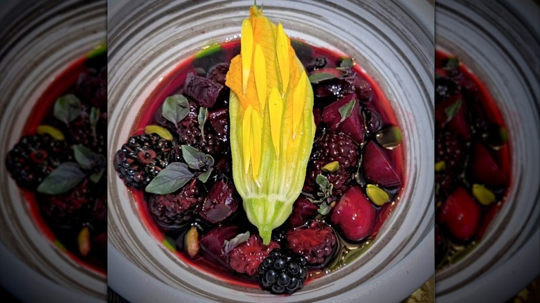 Berries with cheese, basil leaves, and squash on a decorative plate at Bosq
