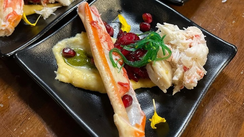 Crab and seaweed salad on a square black plate at Candle in the Woods