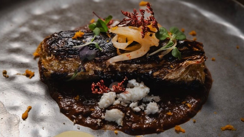 Duck enchilada with kimchi and black garlic molé at OMA