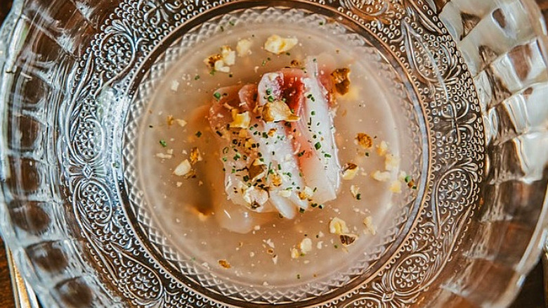 Fish crudo on a glass plate at Sassafras