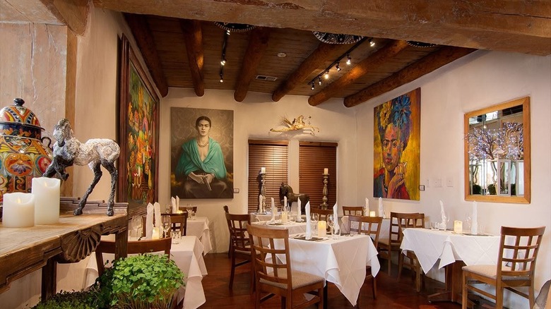 Dining room at Sazón with paintings on the walls