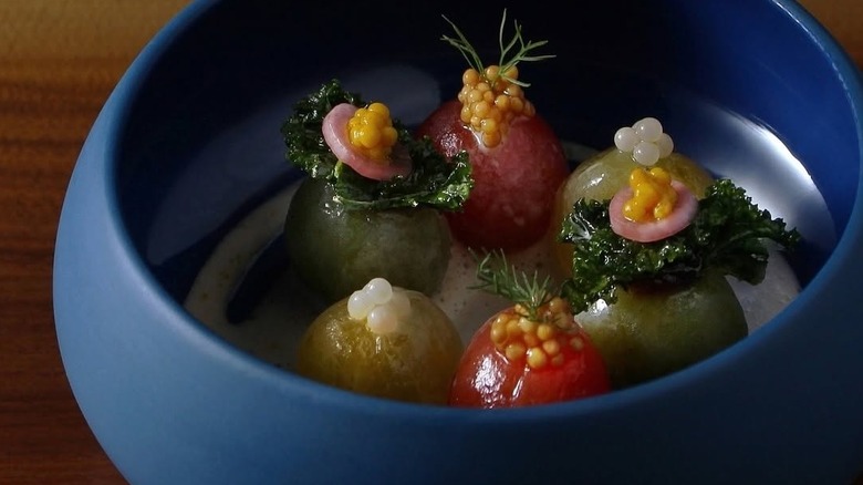 Peeled tomato course in a blue bowl at Grey Sweater