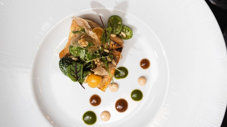 Fish course decorated with microgreens and nuts at Honeysuckle Rose