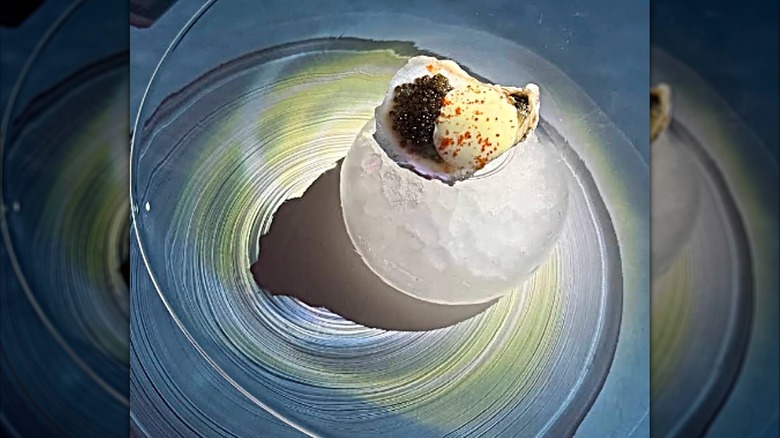Oyster, caviar, and cream course on an ice sphere at Punk Noir