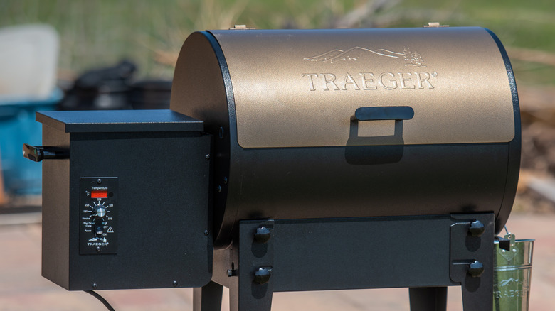 a Traeger wood pellet smoker with pellet box on the left side