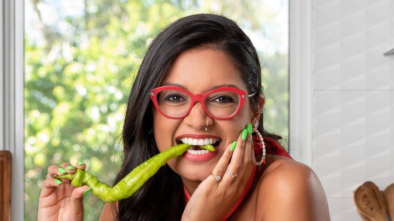 Priyanka Naik smiling and eating a pepper