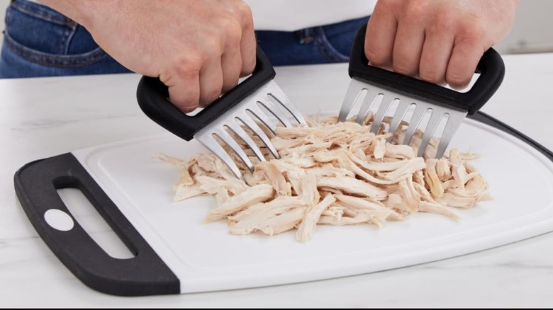 A person shredding chicken with the Gorilla Grip meat claws