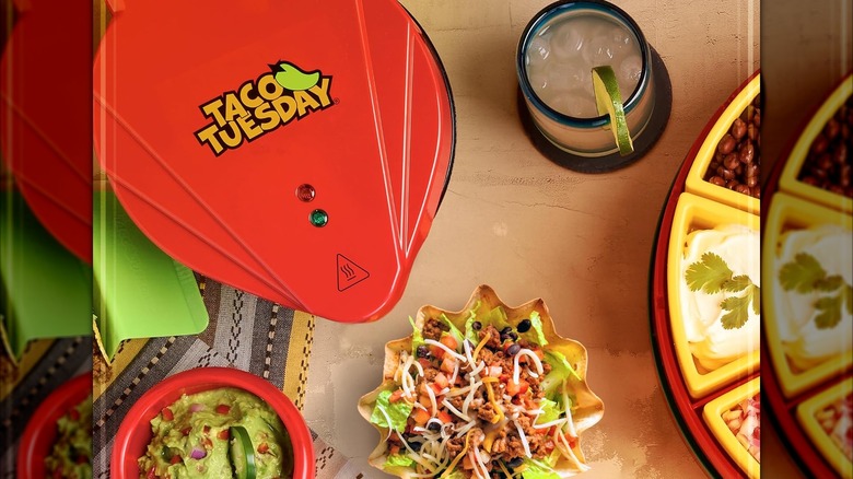 A Nostalgia tortilla bowl maker with a filled tortilla bowl