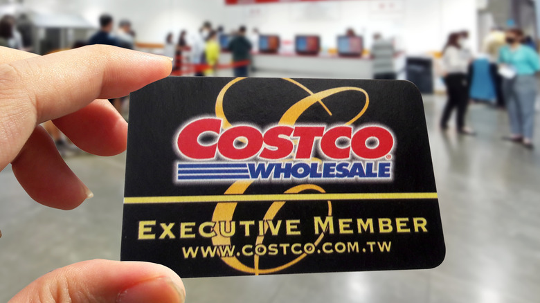 Hand holding Costco Executive Membership card inside store