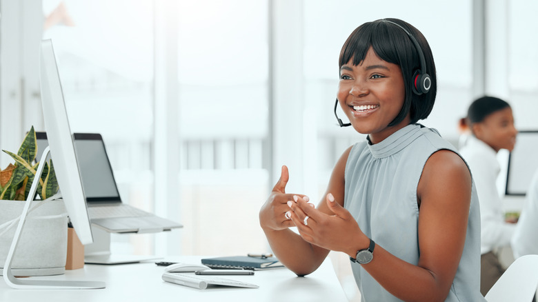 Customers support woman with headset in front of computer