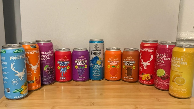 line up of various protein soda brands on table