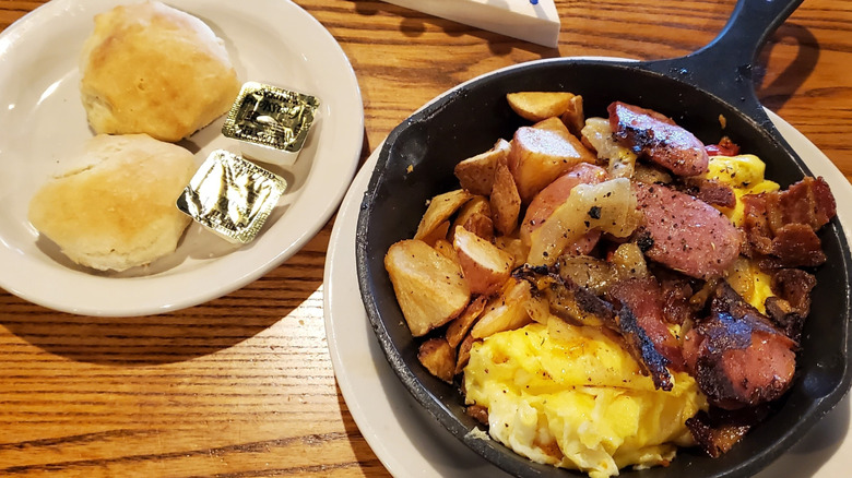 Cracker Barrel Campfire Breakfast Skillet with two buttermilk biscuits and two packets of butter