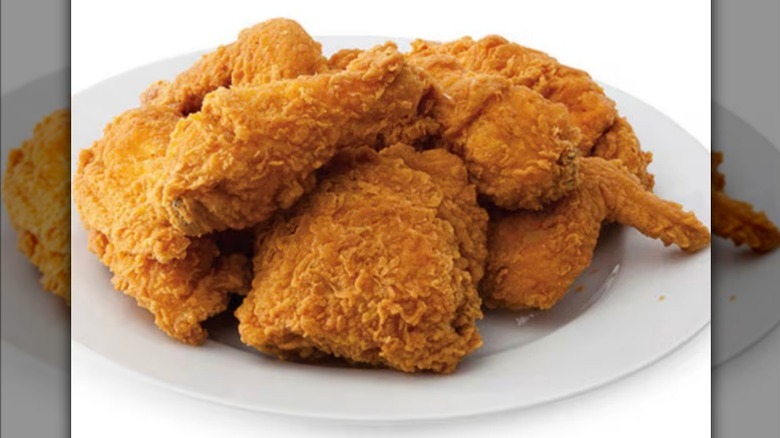 Fried chicken on plate with tongs