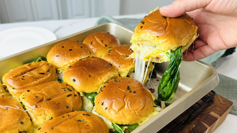Hand removing slider from baking dish