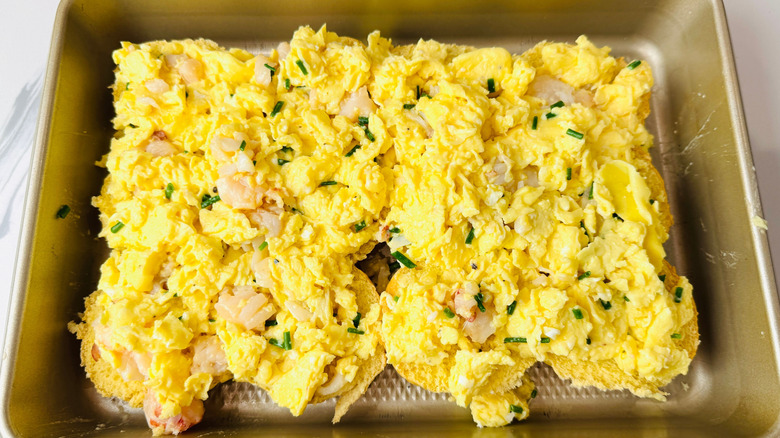 Lobster scrambled egg mixture on bottom buns in baking pan