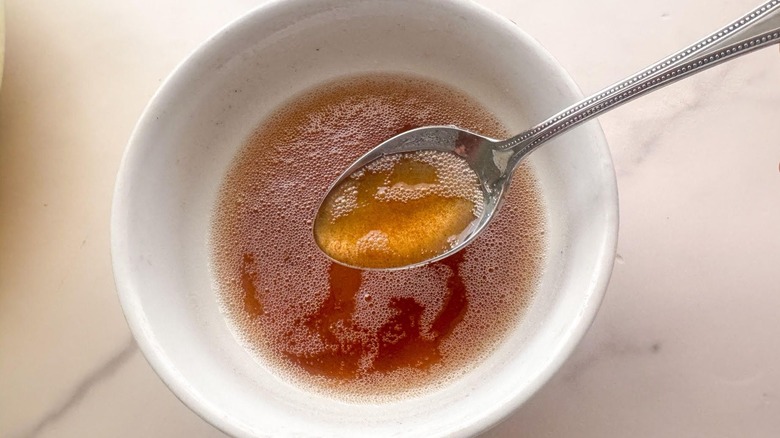 Brown butter in bowl with spoon holding small amount