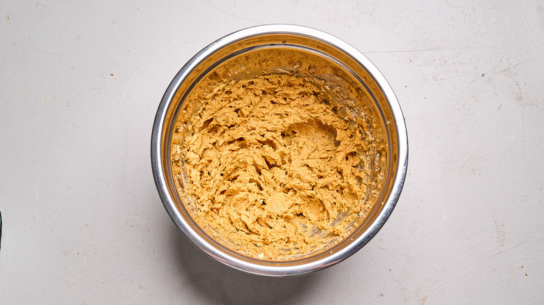 pumpkin added to batter in bowl
