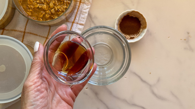 hand adding syrup to bowl