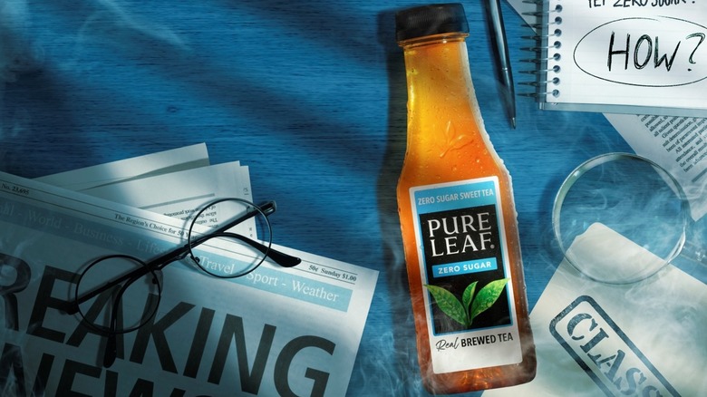 A bottle of Pure Leaf Zero Sugar Sweet Tea next to glasses and papers