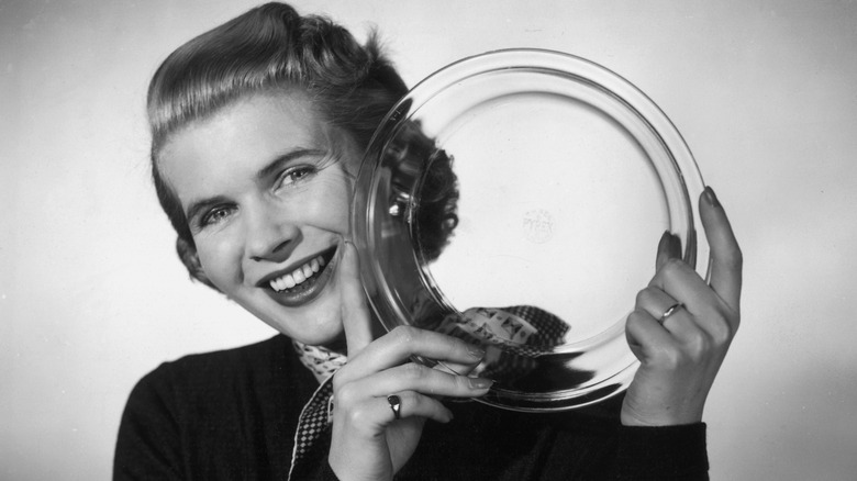 A housewife displays "Pyrex" dishware in 1955