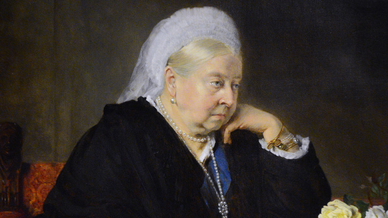Queen Victoria sits resting her head on her hand in a painted portrait.