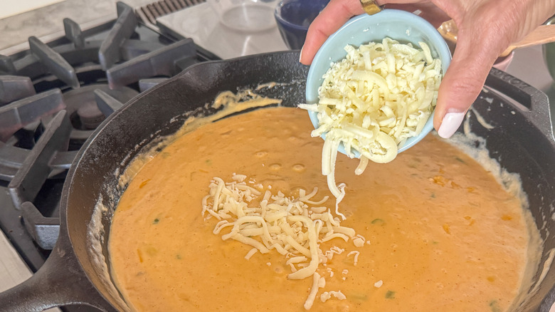 hand adding cheese on top