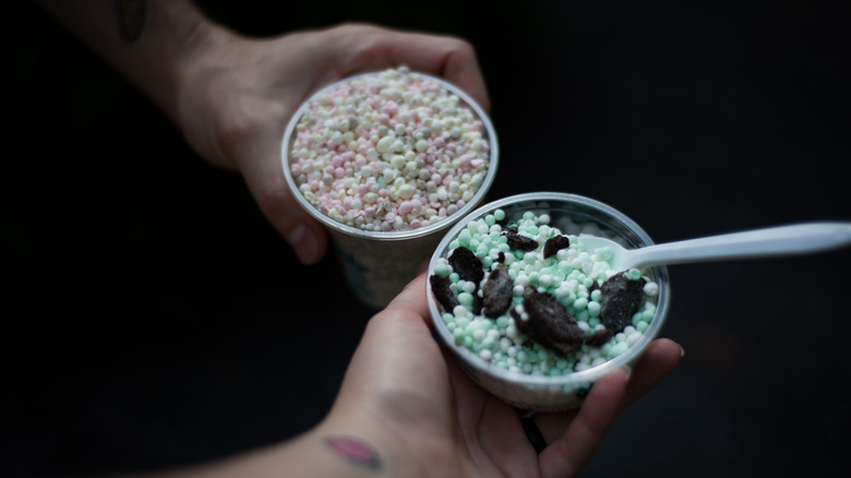 hands holding Dippin' Dots cups