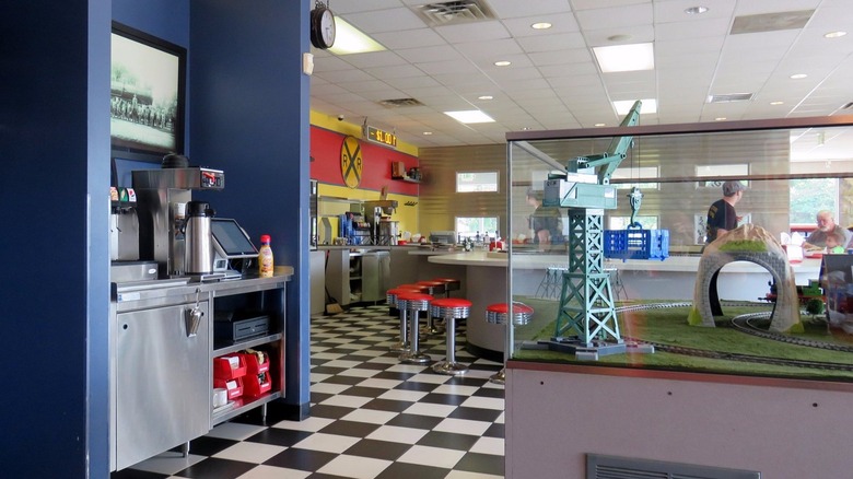 Interior of a train-themed restaurant with railroad signs and model trains