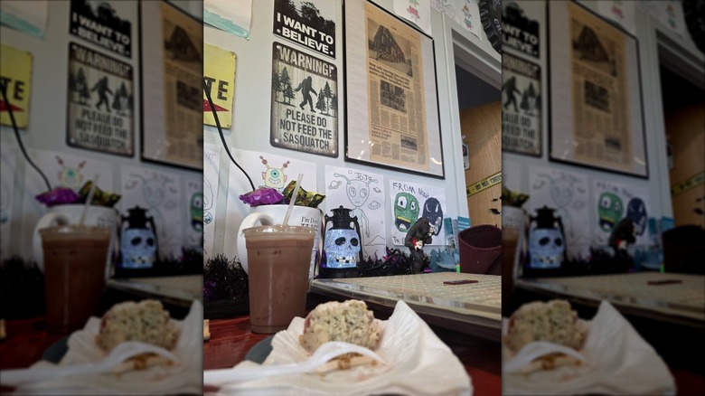 Table with scones, coffee, and paranormal-themed wall art