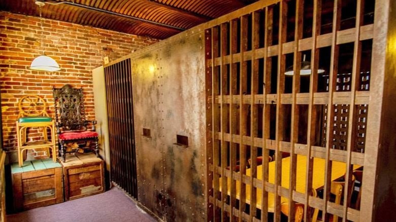 Table and chains inside an olde-timey jail cell