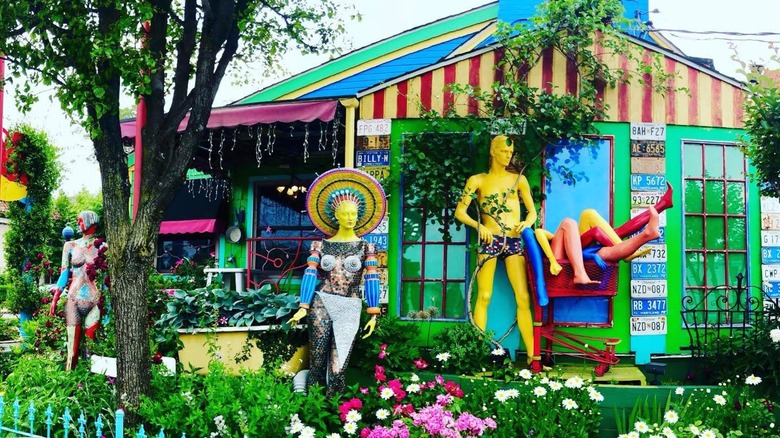 Brightly colored building with mannequins and a garden