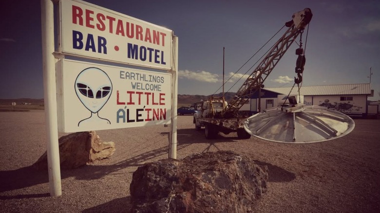 Sign for the Little A'Le'Inn with a truck and flying saucer