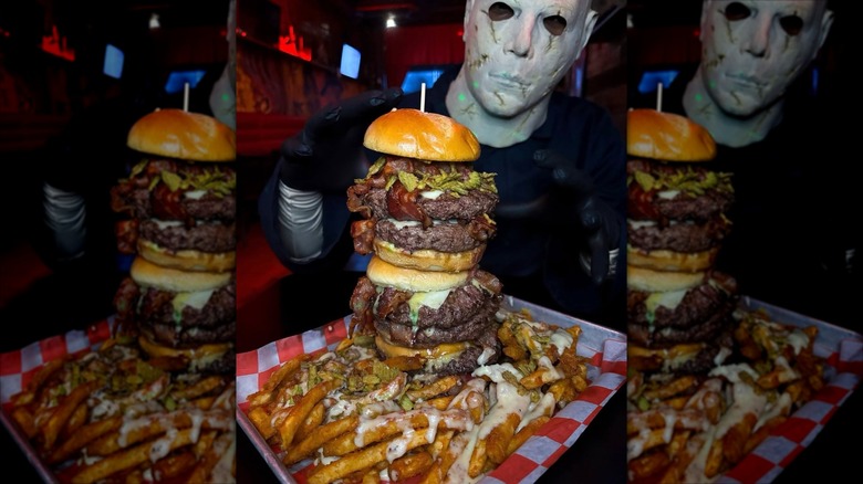Tray with a giant hamburger and fries held by Michael Myers