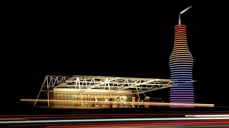 Exterior of Pops at night with lights and a giant pop bottle structure