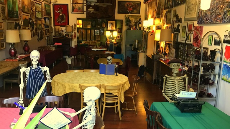 Interior of a restaurant with fake skeletons sitting at the tables