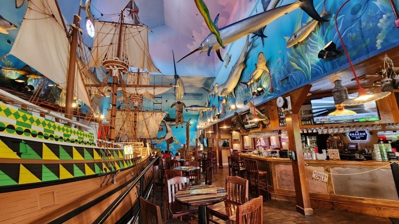 Nautical-themed restaurant with a ship and mounted animals on the ceiling