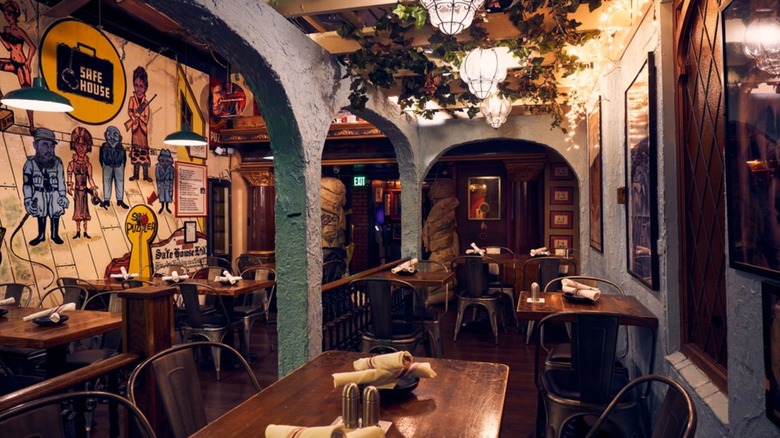 Tables and vaulted arches with a mural inside SafeHouse
