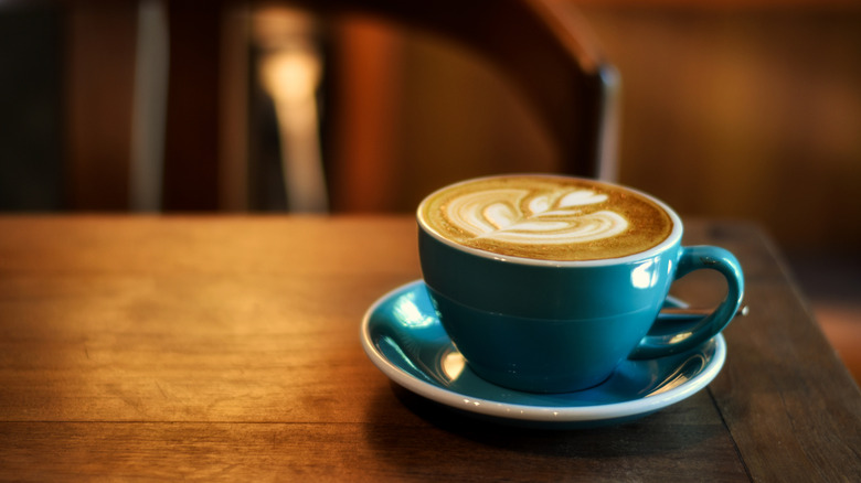 coffee in blue ceramic cup with latte art