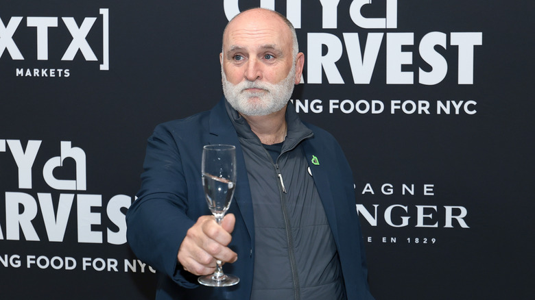 José Andrés holding a flute glass of champagne at a promotional event.