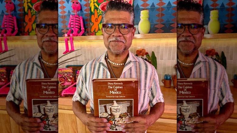 Martínez holding a copy of Diana Kennedy's book at his home in Mexico