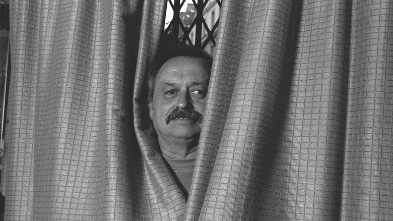 Jim Harrison posing with curtains