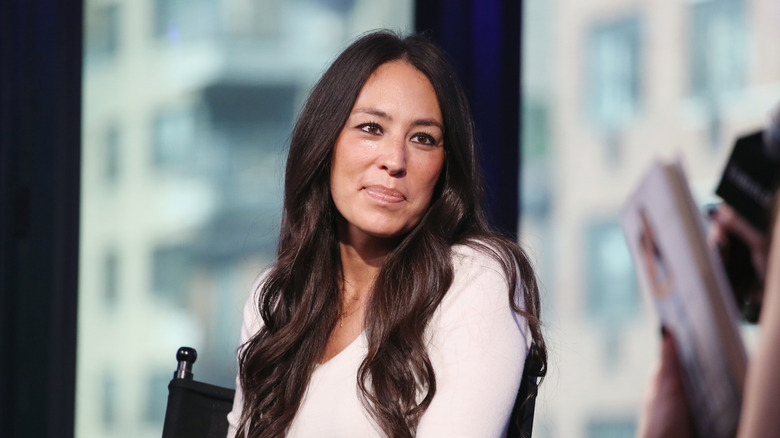 Joanna Gaines wearing a white sweater with her head slightly tilted.