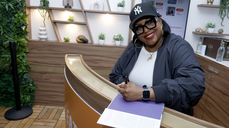 Kardea Brown smiling while signing one of her cookbooks at 2019 Food Network New York City Wine & Food Festival