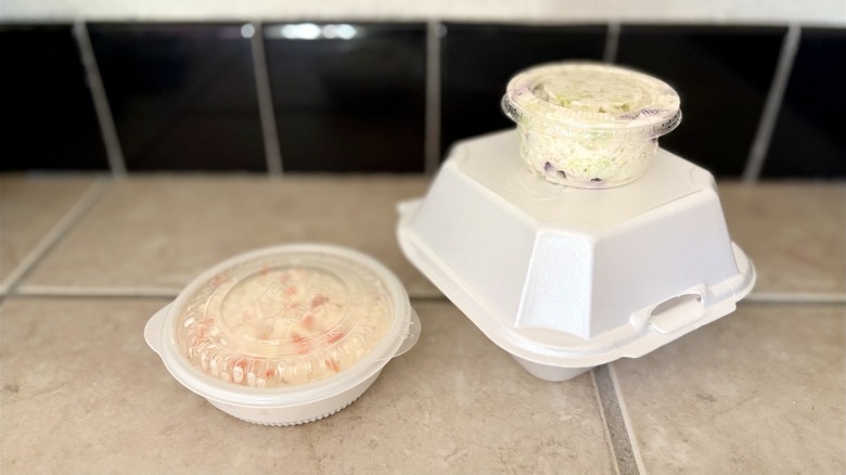 Two ramekins of cole slaw with lids on top
