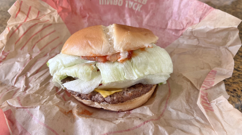Jack in the Box Jumbo Jack Cheeseburger with a paper wrapper