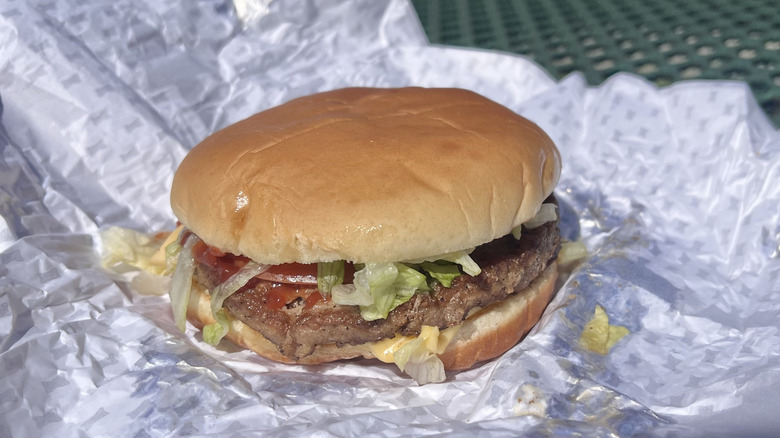 Close/up image of a Sonic Sonic Cheeseburger with its wrapper